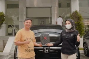 Sales Resmi Honda Padang Pipit sedang memberikan penjelasan simulasi paket kredit DP minim untuk New Honda HR-V e:HEV RS